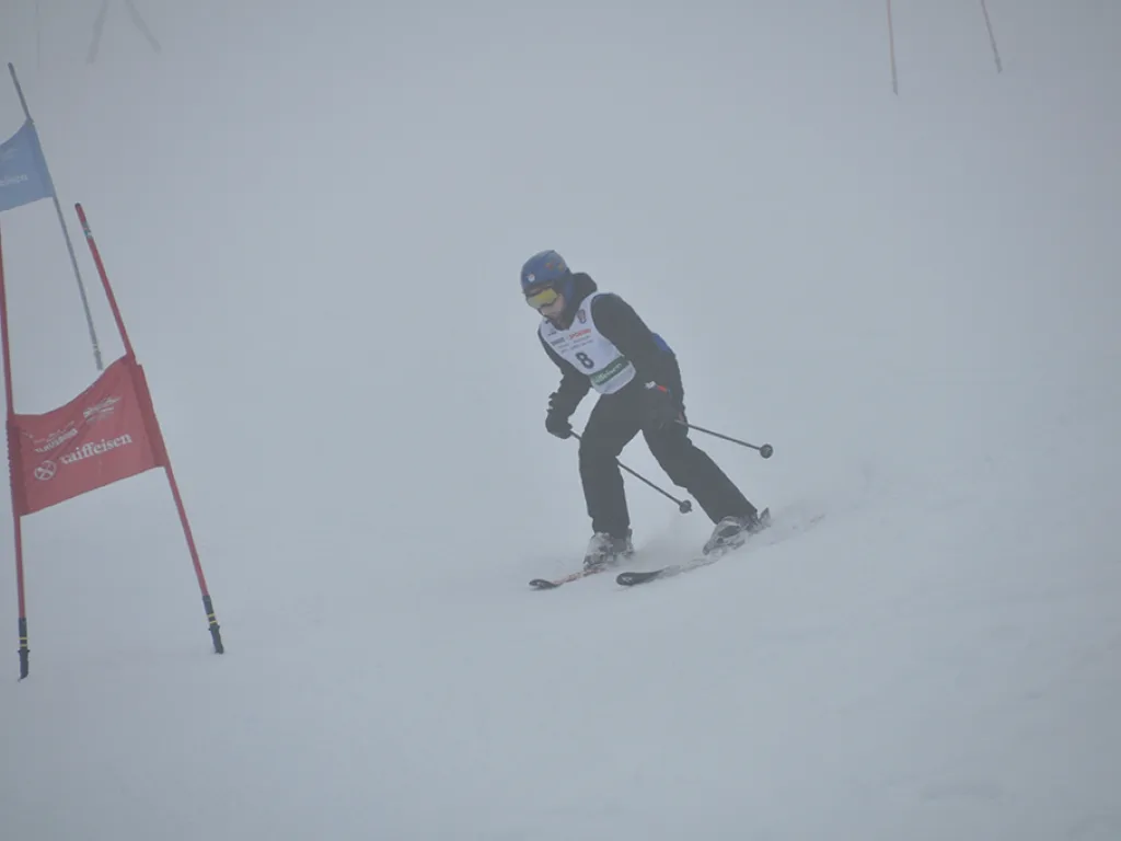 Skifahrer fährt an einem roten Tor vorbei.